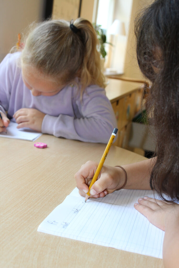 Unga skolelever under lektionstid övar på att skriva